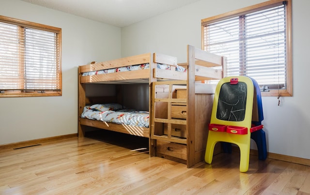 bedroom with hardwood / wood-style floors and multiple windows