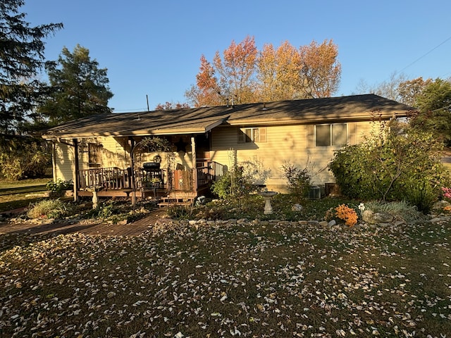 rear view of property featuring cooling unit and a deck