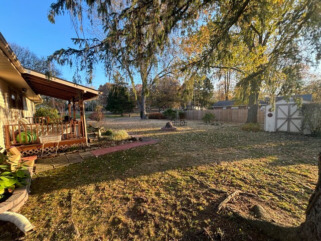 view of yard with a wooden deck and a storage shed