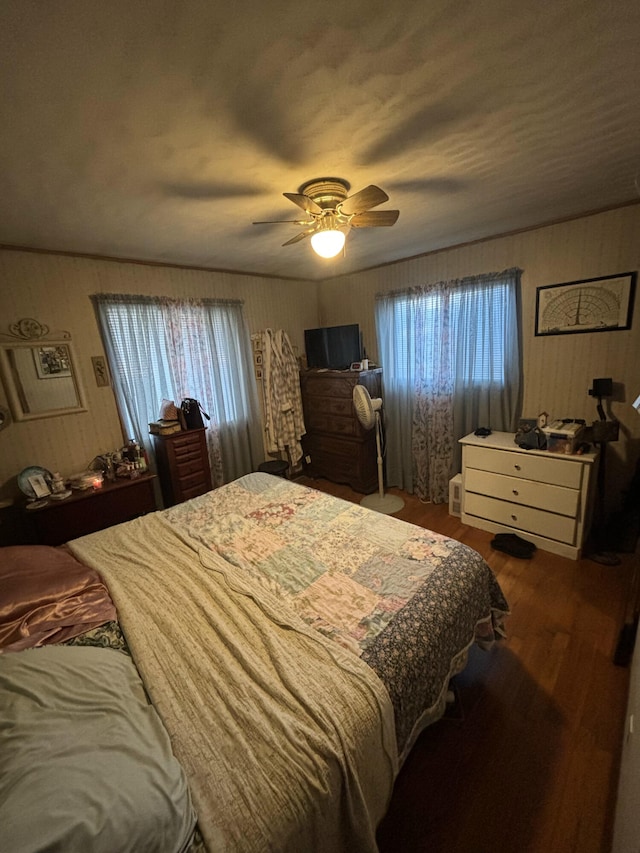 bedroom featuring hardwood / wood-style floors, ceiling fan, and multiple windows