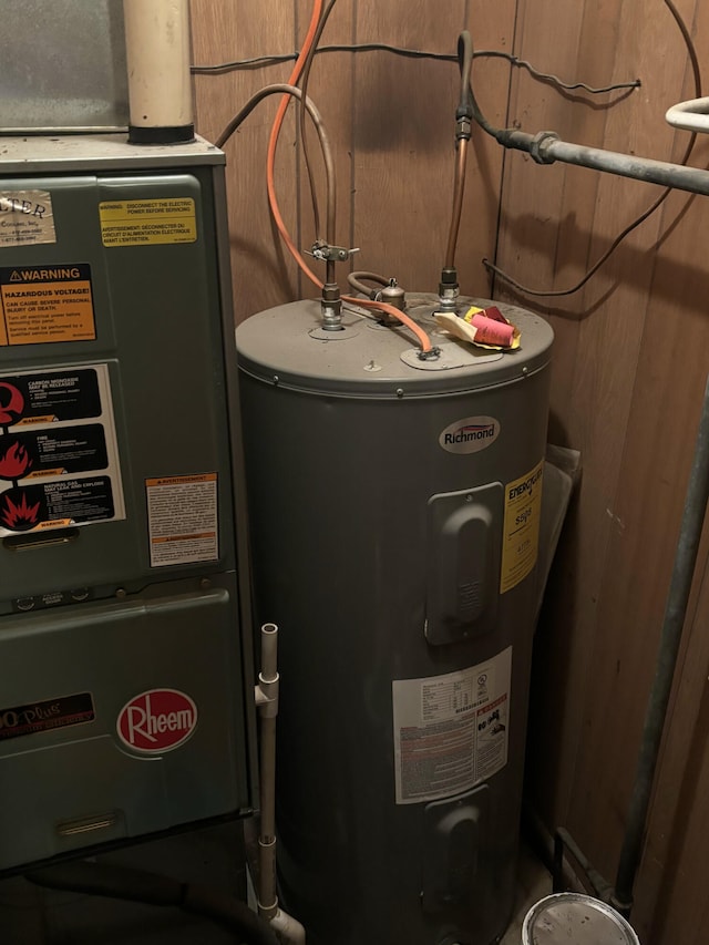 utility room featuring heating unit and electric water heater