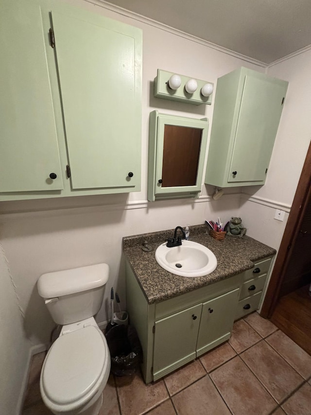 bathroom with toilet, vanity, tile patterned floors, and crown molding