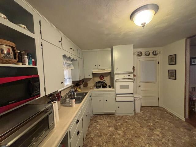 kitchen featuring white appliances, white cabinetry, and sink