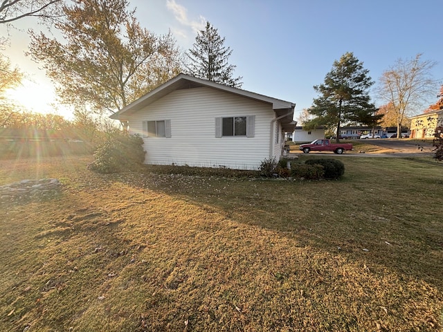 property exterior at dusk with a lawn