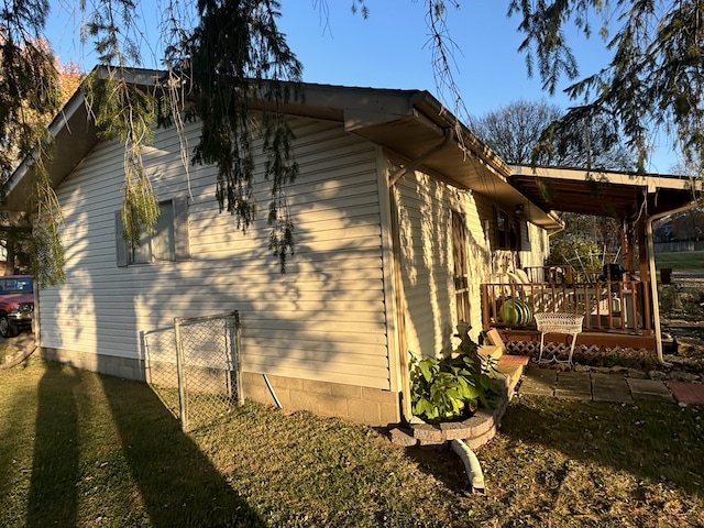 view of home's exterior with a deck and a lawn