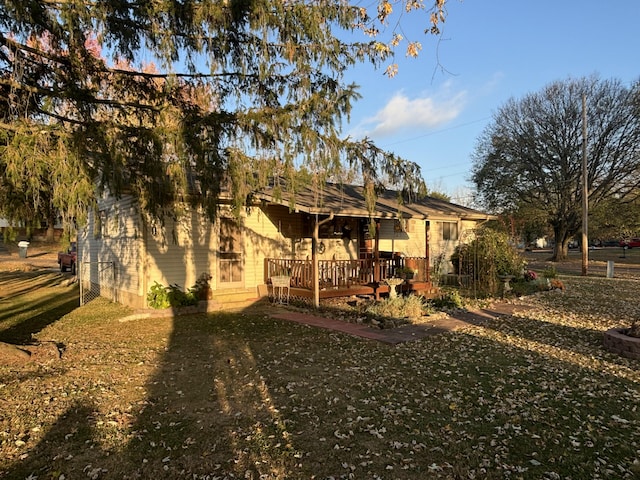 back of house featuring a wooden deck and a yard