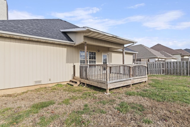 back of property featuring a lawn and a deck