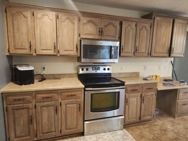 kitchen with light tile patterned floors and appliances with stainless steel finishes