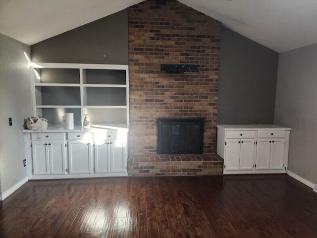 unfurnished living room featuring built in features, lofted ceiling, and dark hardwood / wood-style floors