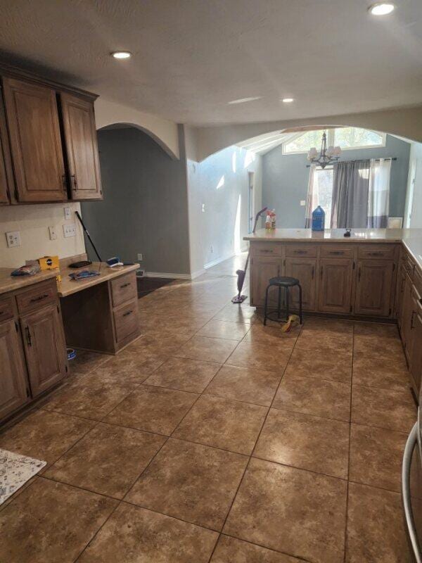 kitchen featuring dark tile patterned floors and a chandelier