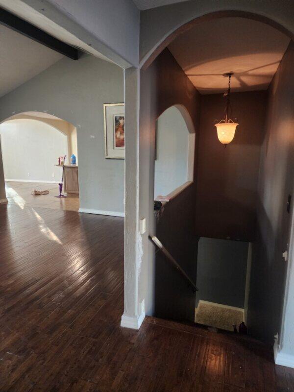 hall featuring lofted ceiling with beams and dark hardwood / wood-style flooring