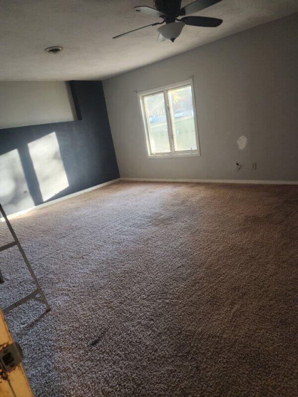 empty room with ceiling fan and carpet flooring