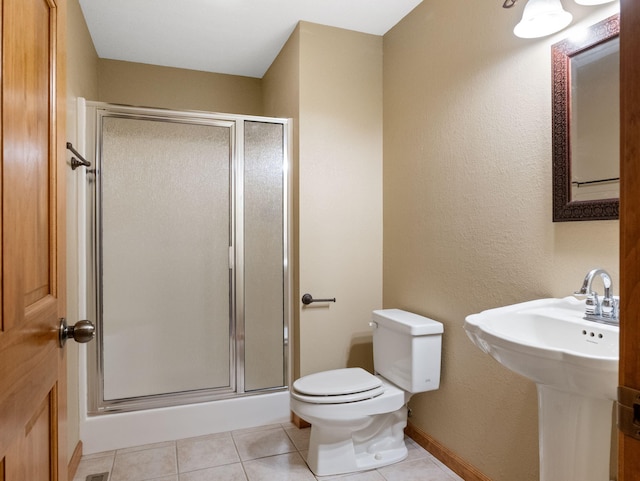 bathroom with tile patterned flooring, an enclosed shower, sink, and toilet