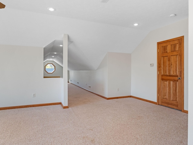 bonus room with light colored carpet and lofted ceiling