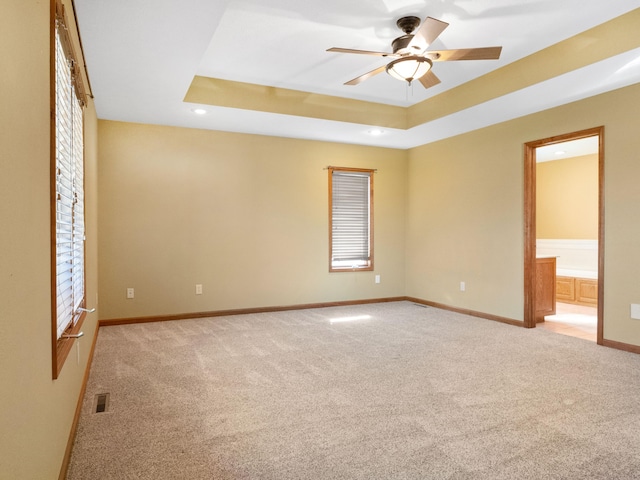 empty room featuring ceiling fan, light colored carpet, and plenty of natural light