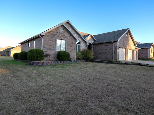 ranch-style home with a garage and a front lawn