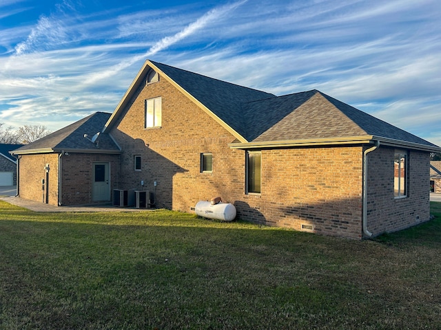 back of property featuring central AC unit and a yard