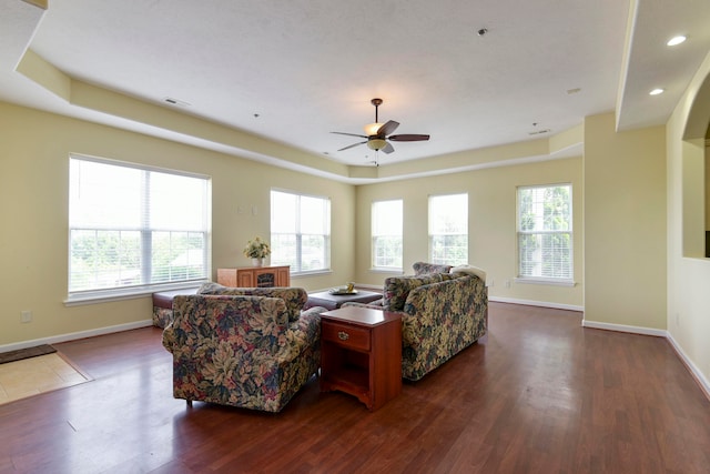 living room with ceiling fan, plenty of natural light, and dark hardwood / wood-style flooring