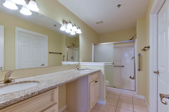 bathroom featuring vanity, a shower with shower door, tile patterned floors, and toilet