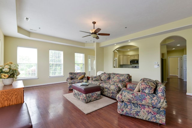 living room featuring ceiling fan, dark hardwood / wood-style floors, and plenty of natural light