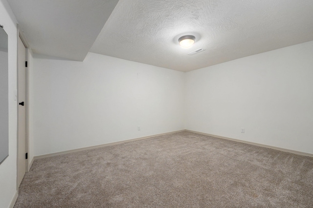 unfurnished room with a textured ceiling and carpet flooring