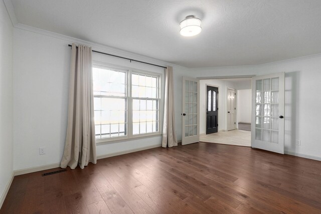 spare room featuring ornamental molding, french doors, wood-type flooring, and a textured ceiling