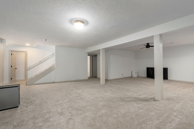 basement with a textured ceiling and light carpet