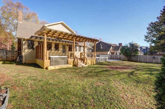 rear view of property featuring a lawn, a jacuzzi, and a pergola