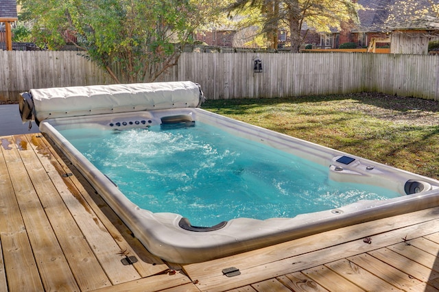 view of swimming pool featuring a deck and a lawn