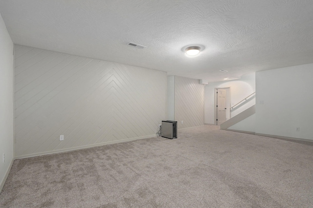 carpeted spare room featuring a textured ceiling