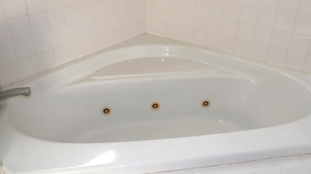 interior details with tile patterned floors and a bath