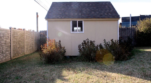 view of side of property with a lawn and a storage unit