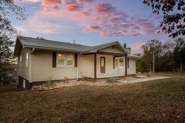 view of front of home with covered porch and a lawn