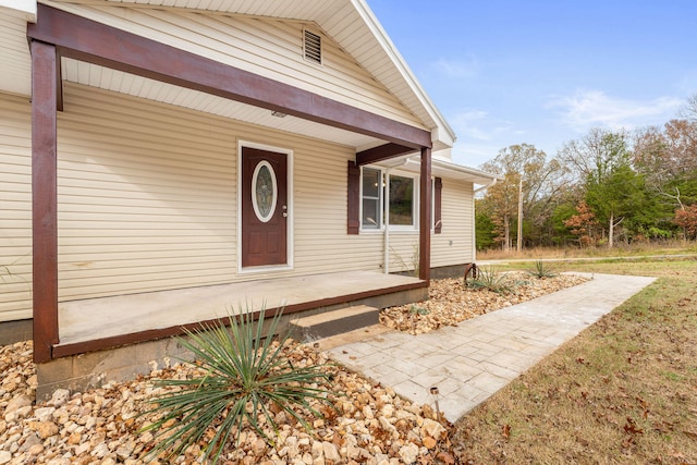 view of exterior entry featuring covered porch