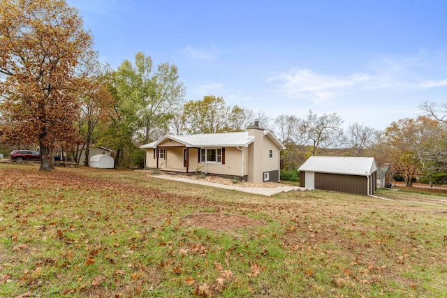 view of front of home with a shed, a front yard, and covered porch