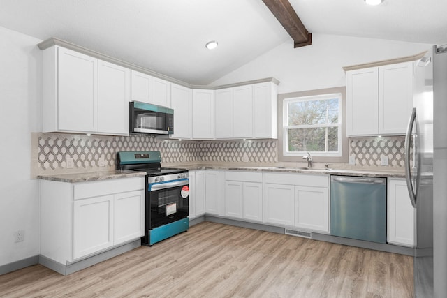 kitchen featuring stainless steel appliances, light hardwood / wood-style floors, sink, and backsplash