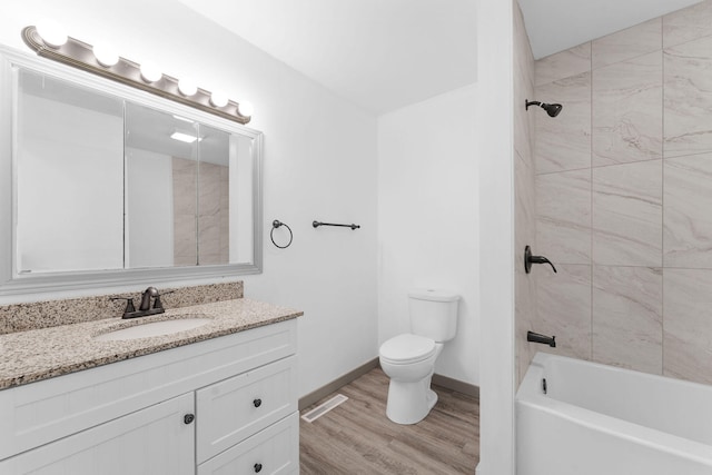 full bathroom featuring wood-type flooring, tiled shower / bath combo, toilet, and vanity