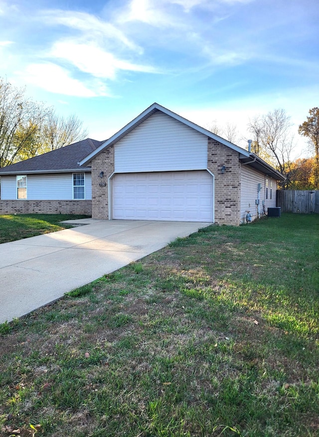 view of front of house with central air condition unit, a garage, and a front yard