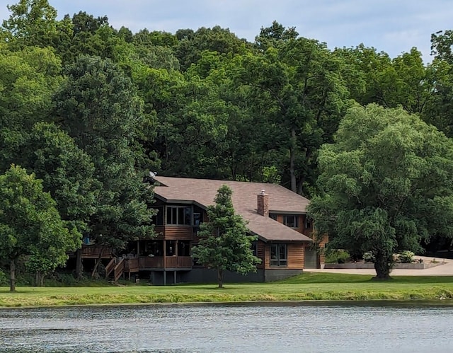 view of front of property featuring a water view and a front lawn