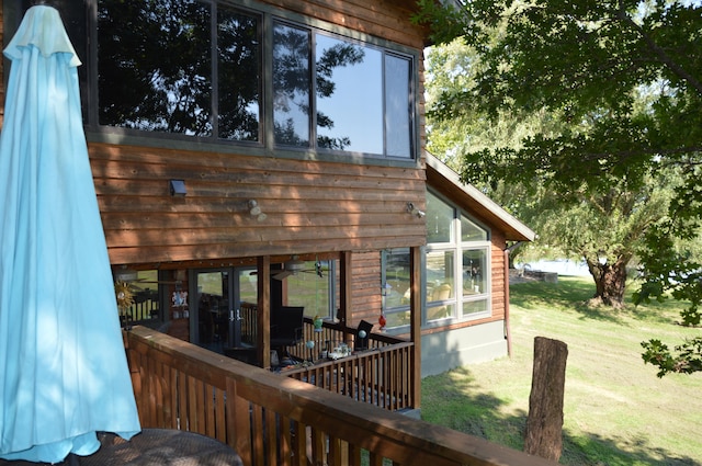 wooden deck featuring a lawn