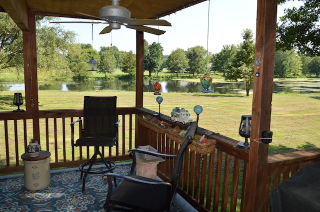 wooden terrace featuring a water view, a yard, and ceiling fan