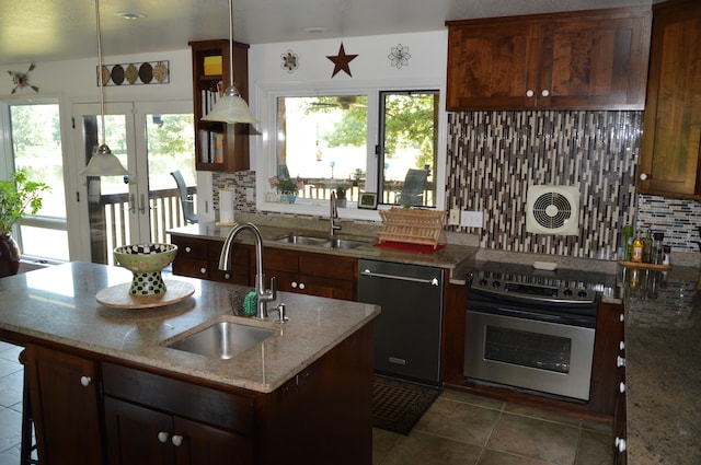 kitchen featuring stainless steel appliances, plenty of natural light, sink, and decorative light fixtures