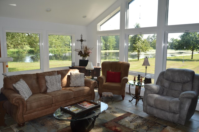 sunroom featuring a healthy amount of sunlight, a water view, and vaulted ceiling