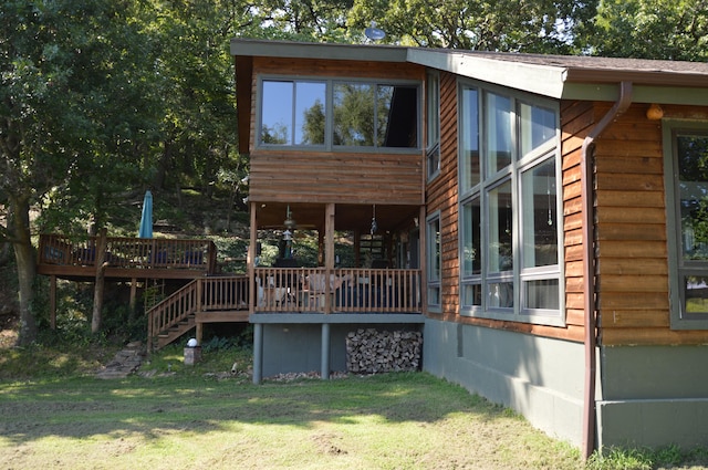 rear view of property with a yard and a deck