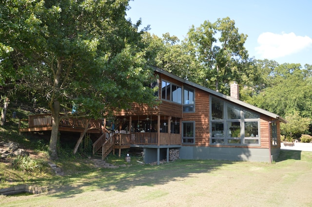 rear view of house featuring a lawn and a wooden deck