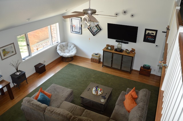 living room featuring hardwood / wood-style floors, ceiling fan, and vaulted ceiling