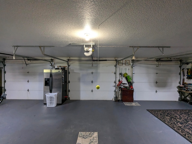 garage featuring a garage door opener and stainless steel refrigerator with ice dispenser