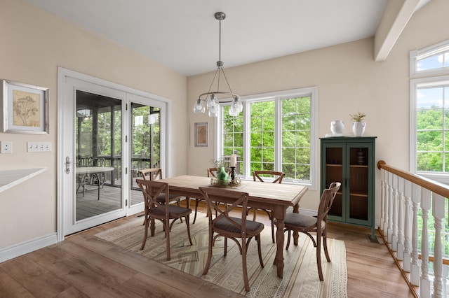 dining area featuring light wood-type flooring and a notable chandelier