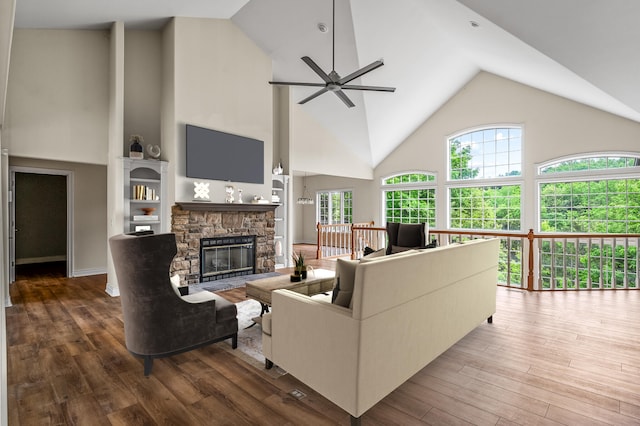 living room with high vaulted ceiling, wood-type flooring, ceiling fan, and a fireplace