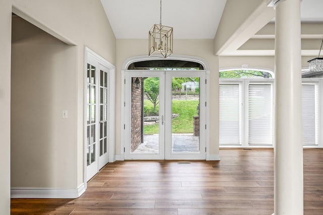 doorway to outside featuring vaulted ceiling, dark hardwood / wood-style floors, french doors, and decorative columns